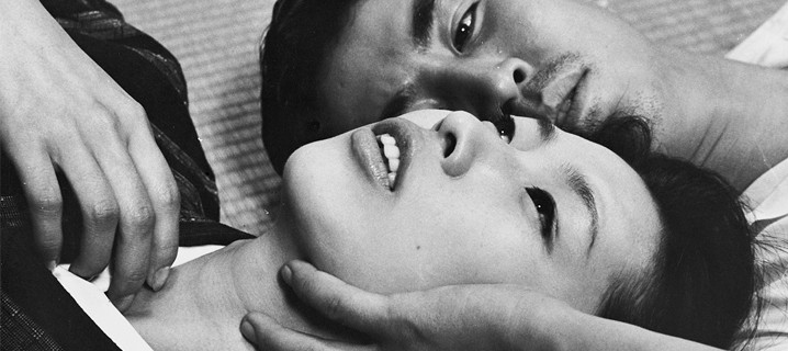 Las dos personas están tumbadas con sus rostros hacia arriba y tocándose