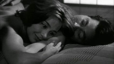 La mujer abraza al amante tumbado sobre la cama