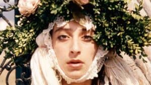 Una mujer lleva un arreglo floral muy primaveral en la cabeza