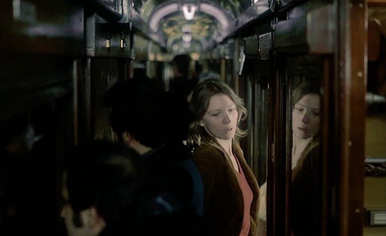 Anna trata de pasar por un pasillo lleno en un tren nocturno