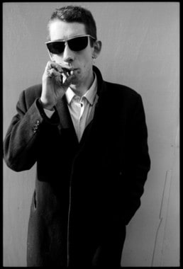 Shane MacGowan on Camden Road, London 12 March 1987, dark glasses and smoking a cigarette