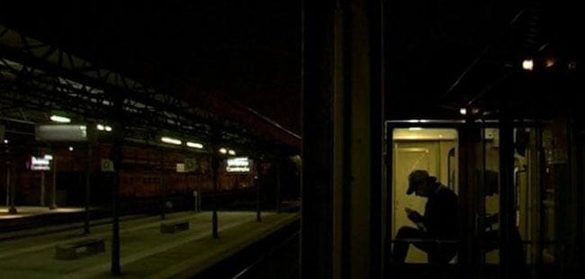 Un anden italiano de noche desde el pasillo de un vagón de tren