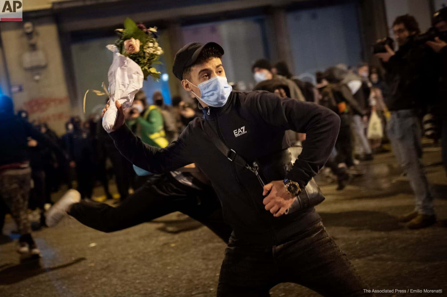 Un joven lanza un ramo de flores contra los antidisturbios formando un icono del pintor Banksy