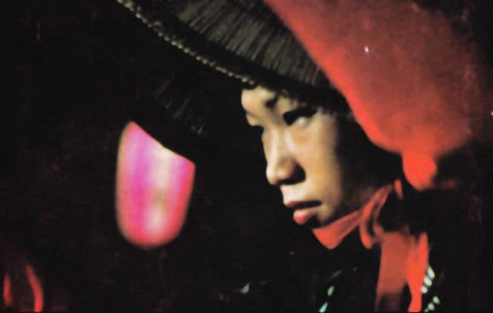 Una niña vietnamita con sombrero de paja mira unas luces nocturnas