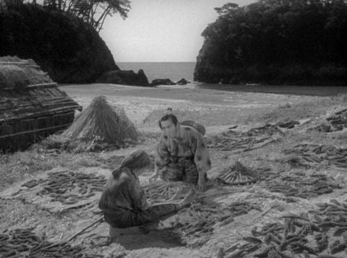 El protagonista encuentra finalmente a su madre en una playa miserable teijendo