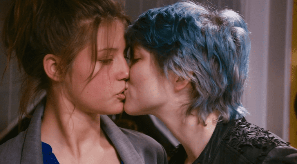 Las dos amantes se besan, una con pasión, la otra confusa