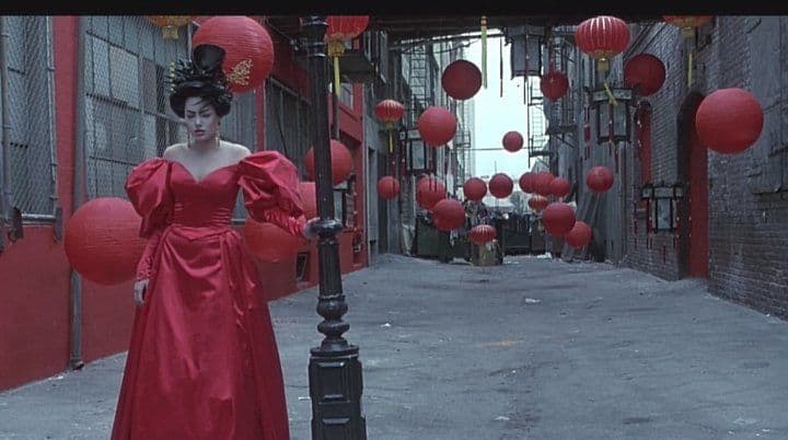 La protagonista con un vestido y bajo unos fanalillos rojos