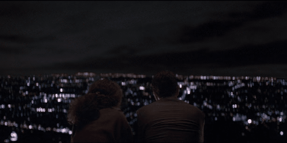 La chica y el gángster charlan mientras contemplan el mar de luces de Los Ángeles