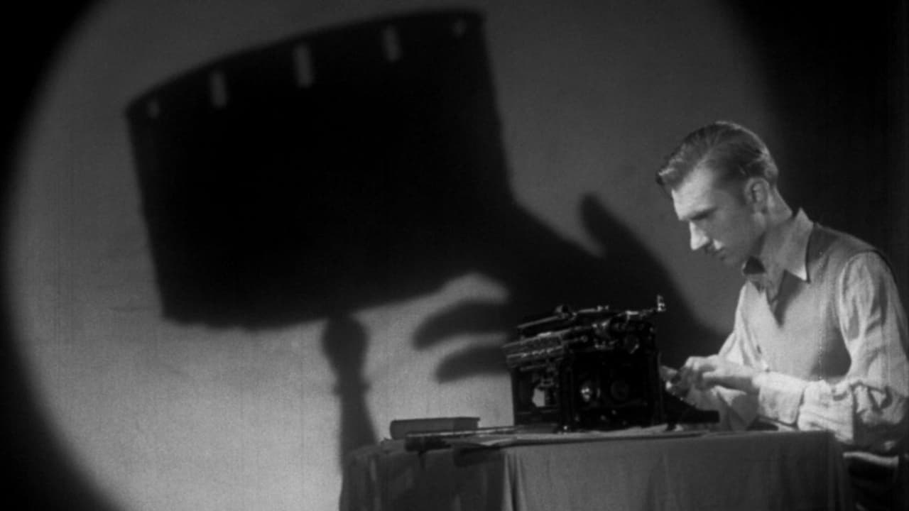 El protagonista escribe sus guiones mientras que una gigantesca sombra de un cinescopio se proyecta sobre la pared