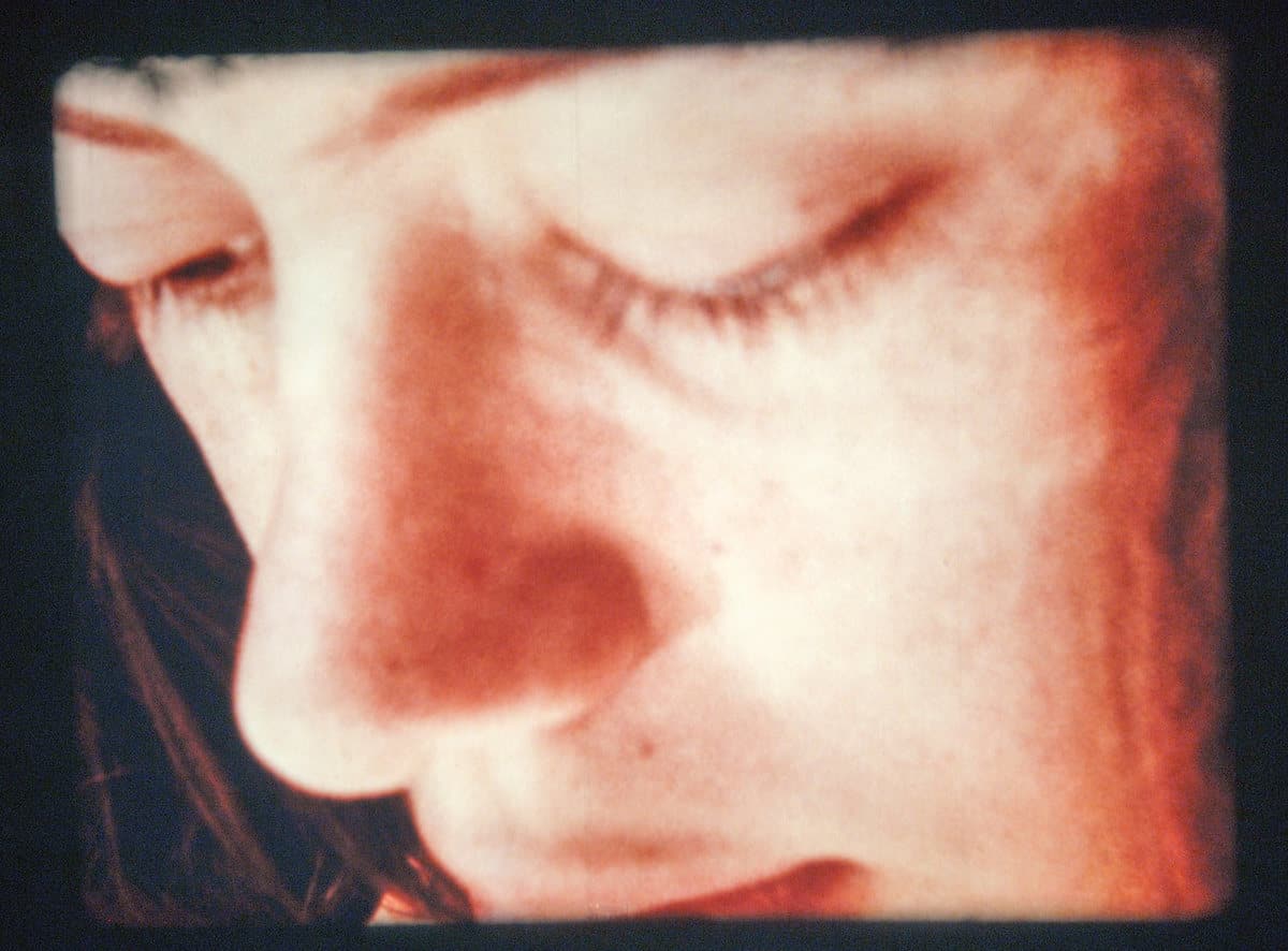 La protagonista mira al bebé que ha parido en la bañera de su casa