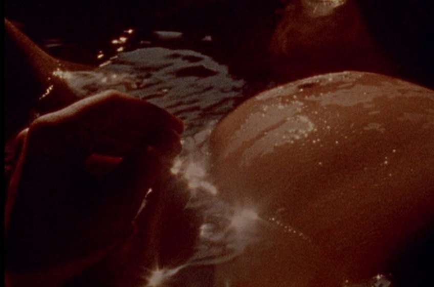 La tripa de la protagonista antes de dar a luz entre reflejos dorados del agua de su bañera