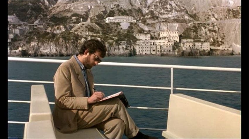 El director lee su diario sentado al sol en la parte de arriba de un ferry