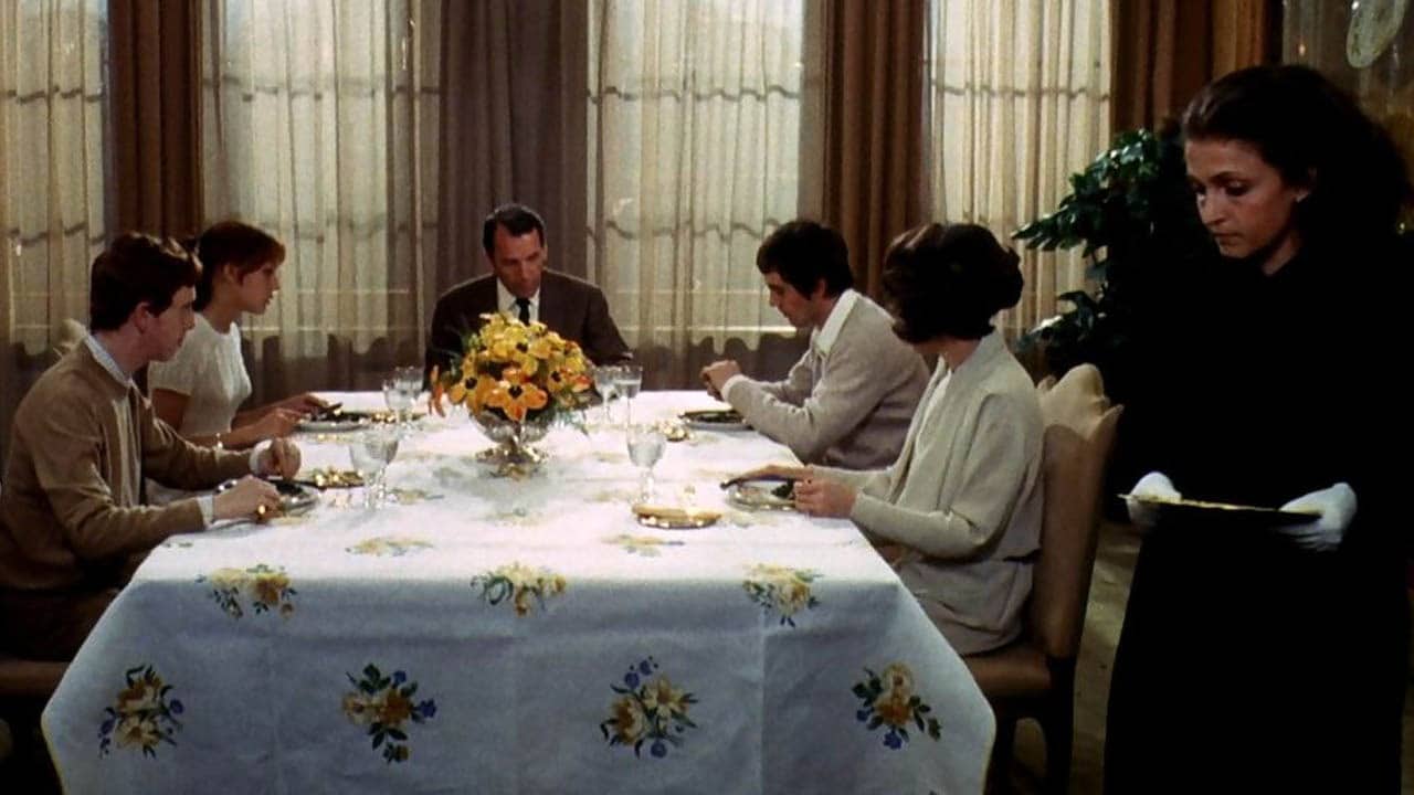 Todos los miembros se reúnen alrededor de la mesa de la comida con el forastero