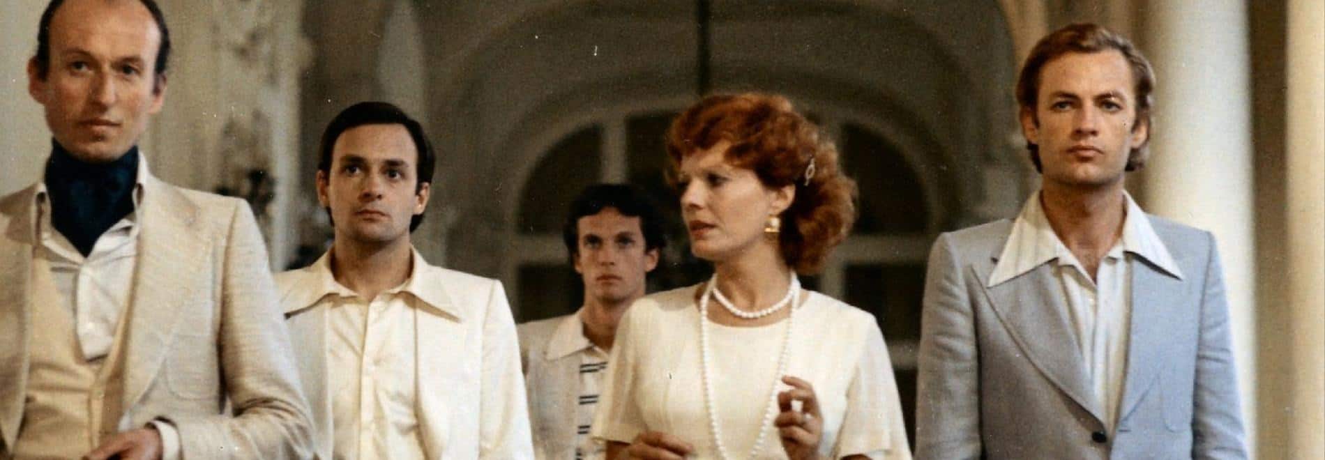 La protagonista avanza con su séquito a través del pasillo hacia la cámara