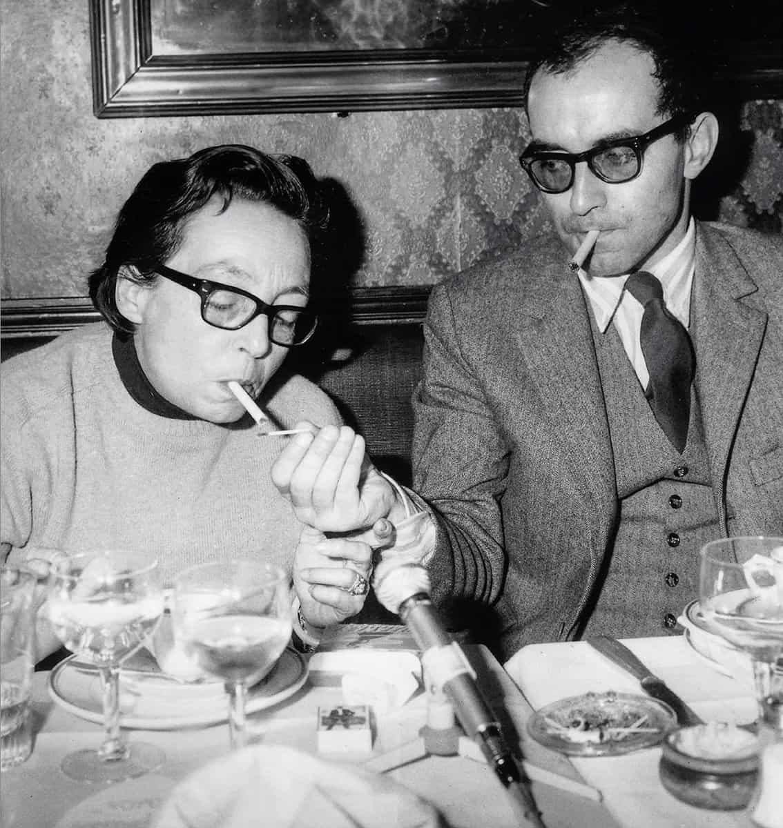 El director enciende un cigarrillo a la escritora