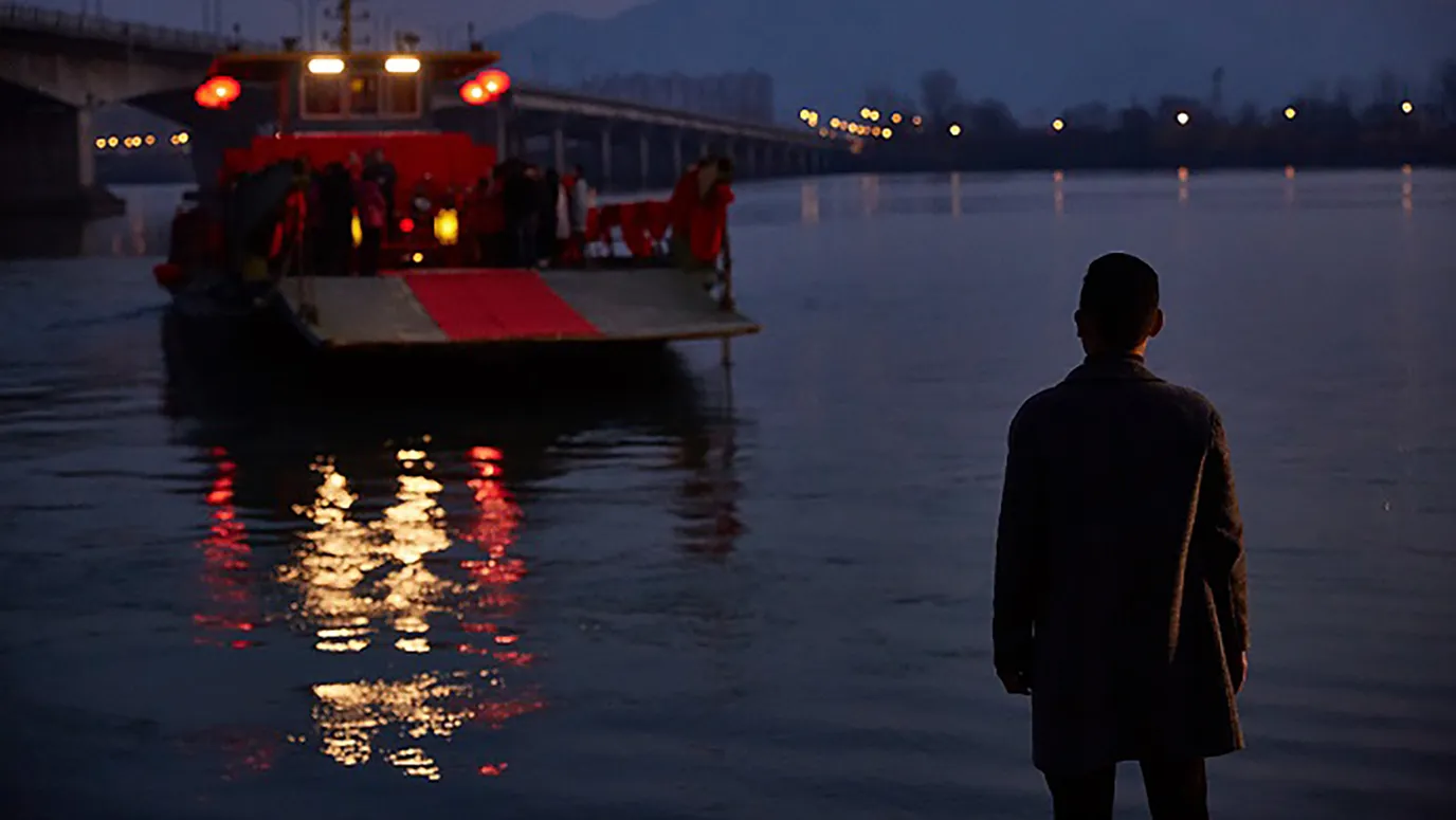 El hijo pequeño ve como su sobrina se casa a bordo de un transbordador que se aleja por el río de noche