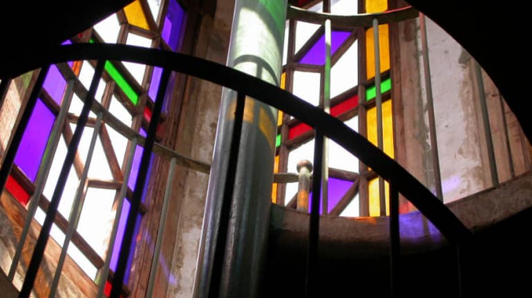 Un vitral luce sus colores en medio de una escalera de caracol