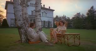 El invitado habla con la mujer sentados en el cesped