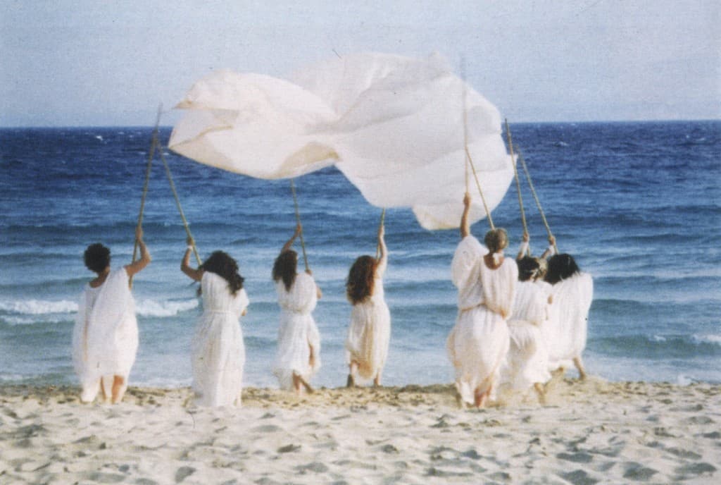Las mujeres vestidas con túnicas blancas se acercan al mar