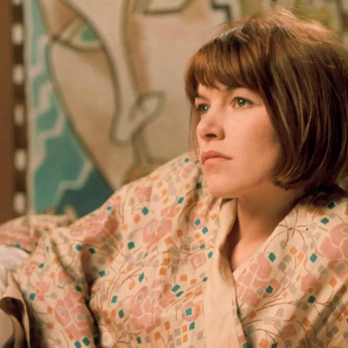 La protagonista, tumbada en la cama con una bata china