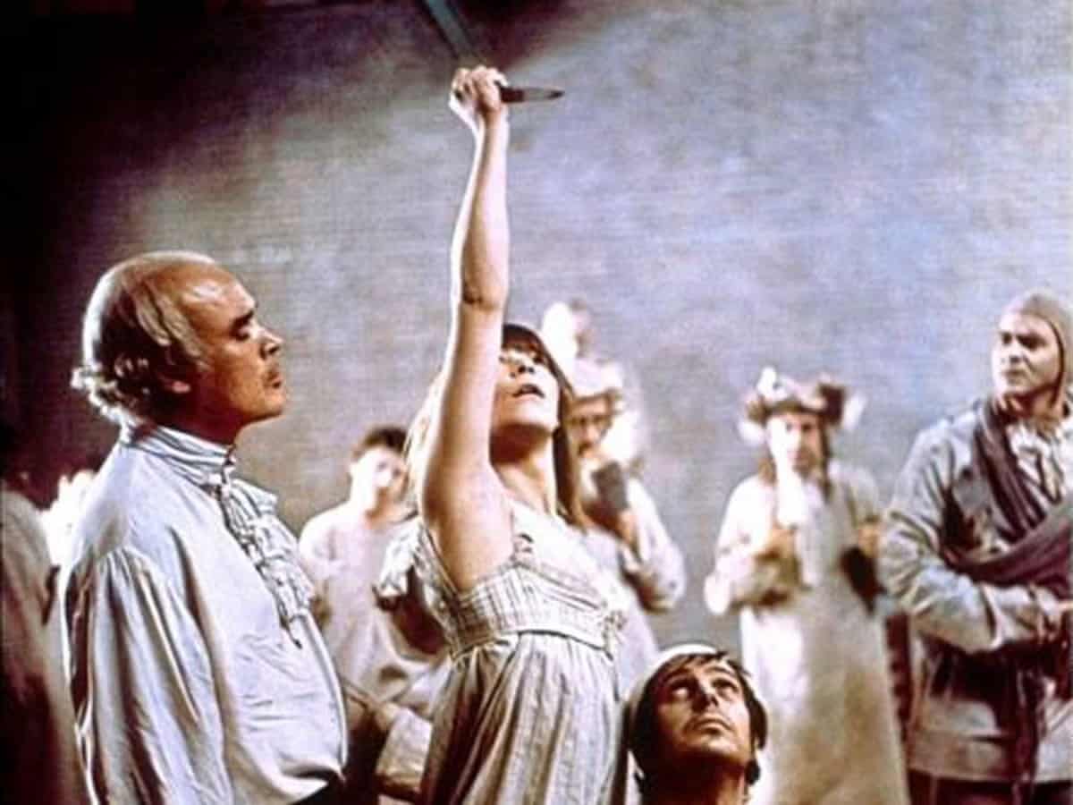 La protagonista alza el cuchillo para matar a Marat ante Sade