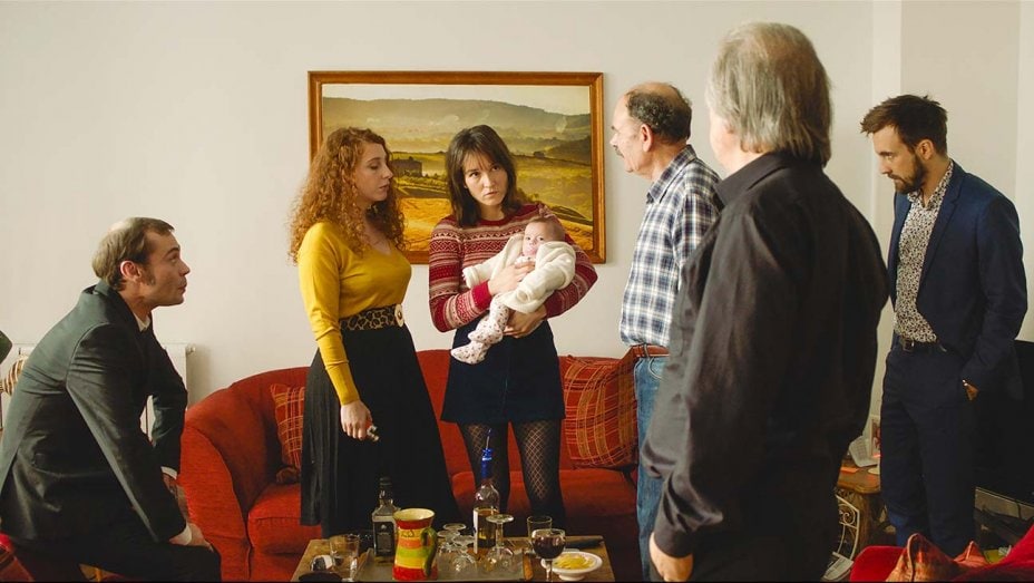 Toda la familia reunida en el salón conversa sobre el bebé
