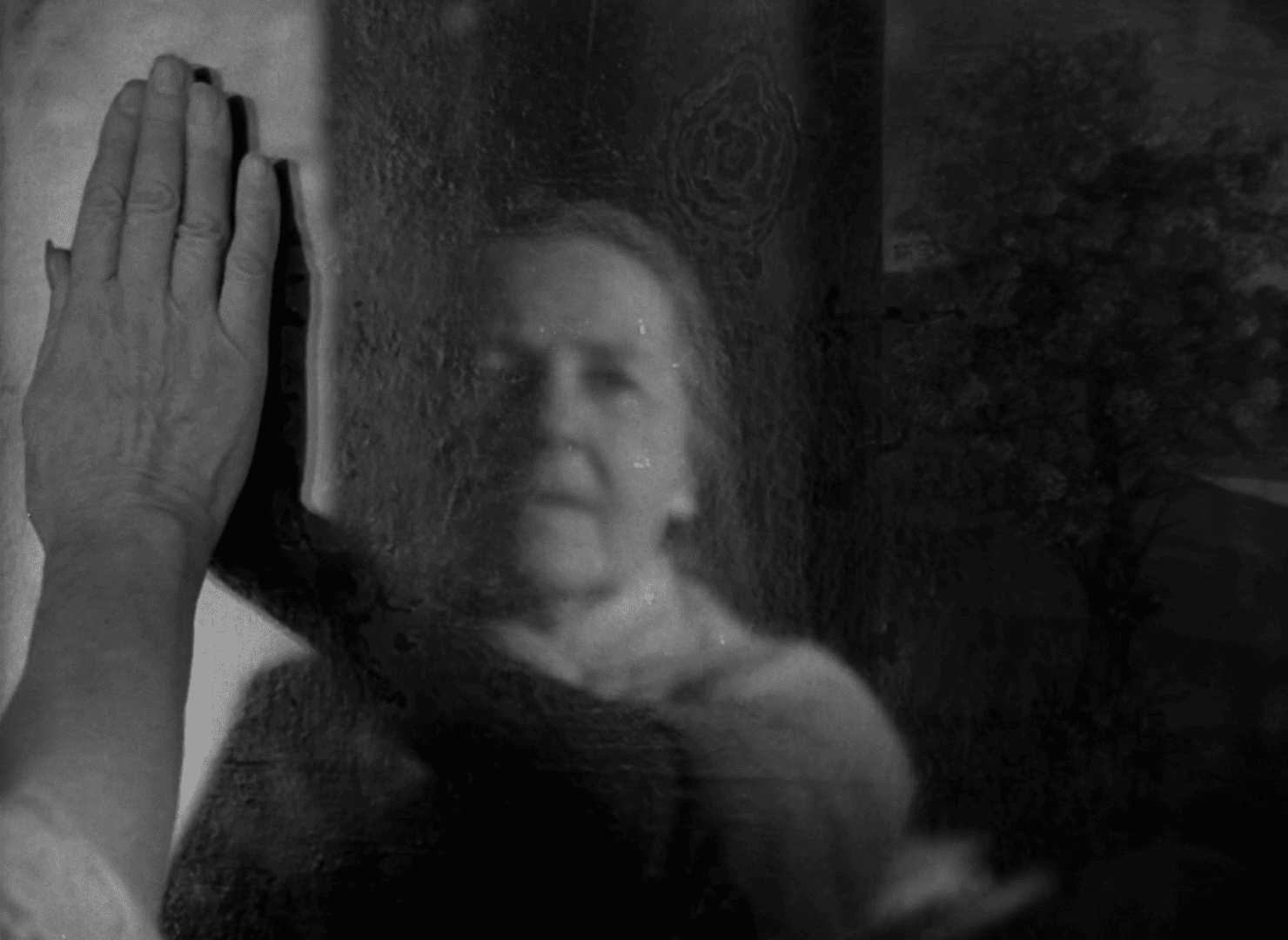 Una anciana trata de limpiar un espejo borroso con la amno