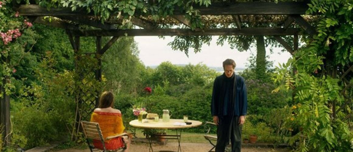 Los protagonistas conversan mientras contemplan Paris desde un jardín