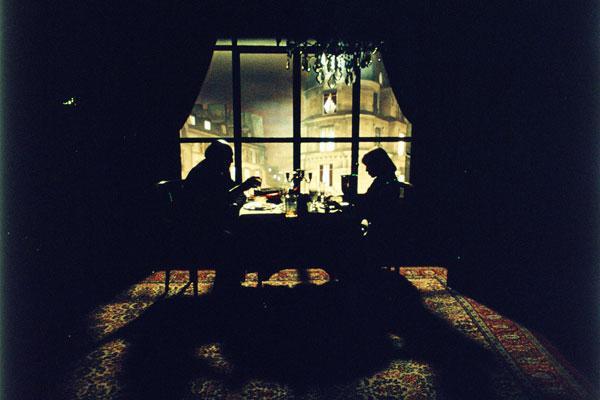 La pareja conversa a la mesa mientras fuera anochece